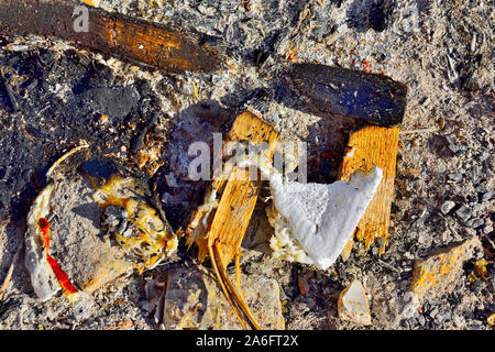 Burned, melted plastic, wood and other waste matter on ground Stock Photo