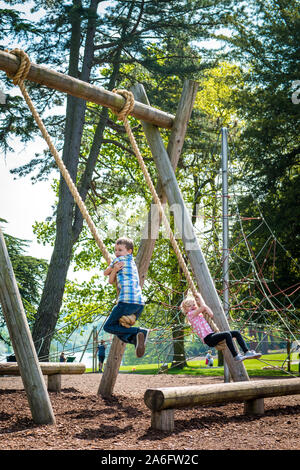 An active, fit boy with ADHD, Autism, Aspergers Syndrome rope climbing with his little sister Trentham Gardens, fit and strong, energetic