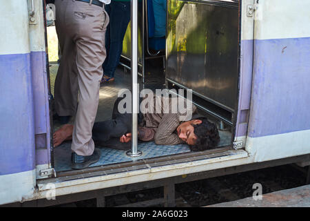 A man sleeping on the local train in Mumbai Stock Photo - Alamy