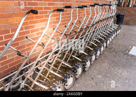 Golf carts for hire, ready for golfer to put their clubs on and go around the course Stock Photo