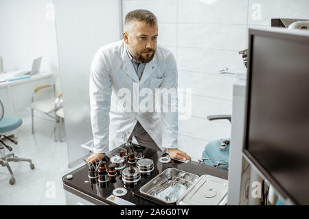 Senior otolaryngologist working in ENT office, examining CT picture of patient's head cavities Stock Photo