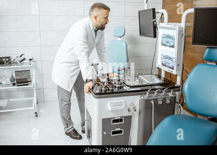 Senior otolaryngologist working in ENT office, examining CT picture of patient's head cavities Stock Photo