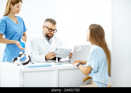 Young patient at an appointment with otolaryngologists, sitting during the consultation in the bright ENT office interior Stock Photo