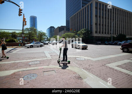 man on lime escooter in downtown city of indianapolis indiana USA Stock Photo