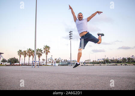 A happy man jumping at park in the morning Stock Photo