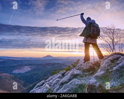 Women adventure, travel and hike people concept. Happy smiling woman walking with backpacks over sharp rocks in autumn morning. Stock Photo