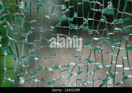 Abstract background of cobweb cracks The texture of the broken cracks. Close-up of a cracked glass. Dirty scratched broken glass of a office door Stock Photo