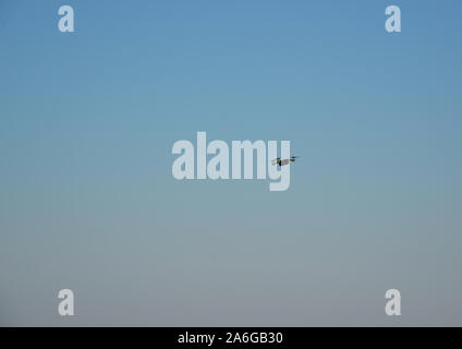 Drone in flight against blue sky. Stock Photo