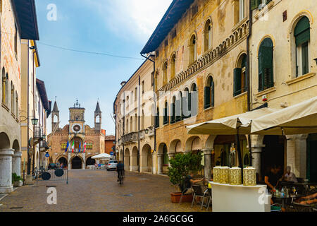 View of typical street in historical center of Pordenone overlooking Gothic building of Town Hall in sunny day, Italy Stock Photo