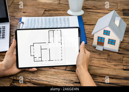 Architect Analyzing House Floor Plan On Digital Tablet Stock Photo