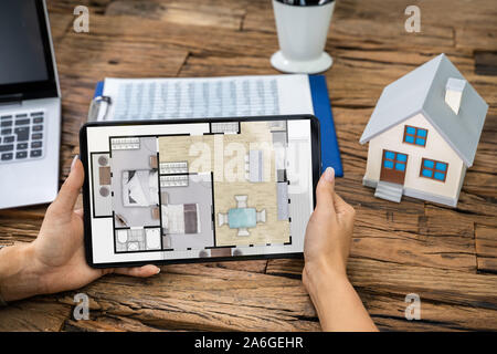 Architect Analyzing House Floor Plan On Digital Tablet Stock Photo
