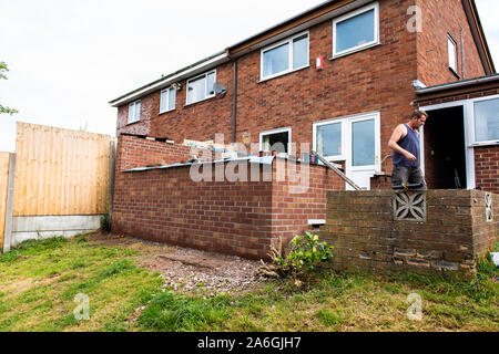 Work commences on the foundations of a conservatory base, laying concrete and brick laying, workmen, ground work, conservatory build, Stock Photo