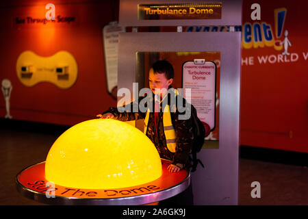 A little boy with ADHD, Autism, Asperger syndrome enjoys a trip to Manchester Science museum with his primary school, wearing a high visibility jacket Stock Photo