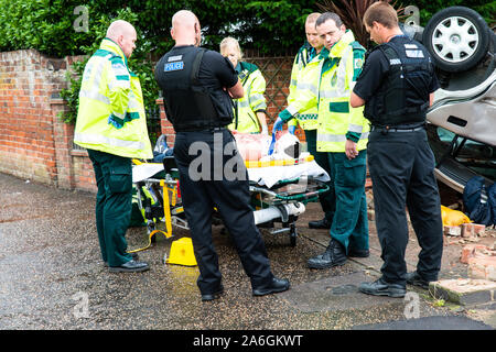 Emergency services on scene at a drink driving accident with an over turned and injured driver, Police, ambulance paramedics and fire brigade, Police Stock Photo