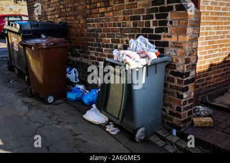 Discarded rubbish and overflowing bins in the back streets of Fenton, Stoke in Trent, recycling, bin collections, poor deprived area, neglected Stock Photo