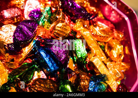 A selection of quality street chocolates in a tin ready to be eaten, Christmas time, festive treats Stock Photo