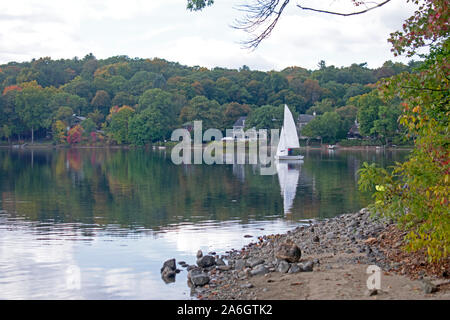 A light breeze sends ripples to the calm waters of Mystic Lake in Arlington, MA, with reflecting white cumulus clouds on the lake's waters. -05 Stock Photo