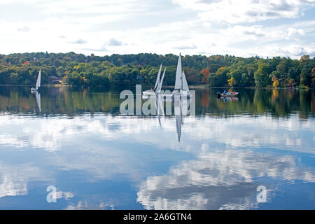 A light breeze sends ripples to the calm waters of Mystic Lake in Arlington, MA, with reflecting white cumulus clouds on the lake's waters. -11 Stock Photo