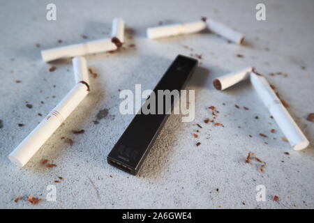 Vape device electronic cigarette juul, as smoking alternative with broken  marlboro gold cigarettes and scattered tobacco on white textured background  Stock Photo - Alamy
