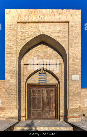 Facade of the ancient Caravanserai Ulugbek Tamokifurush, 19th century, with carved wooden door in Bukhara, Uzbekistan. Stock Photo