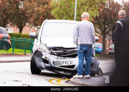 A man standing by his car after being involved in a road traffic accident, crash, RTA waiting for the recovery truck to attend the scene Stock Photo