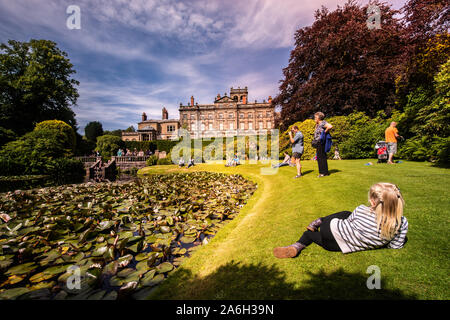 A girl lies on the grass looking at the famous Biddulph Grange building and gardens on a beautiful summers day Stock Photo