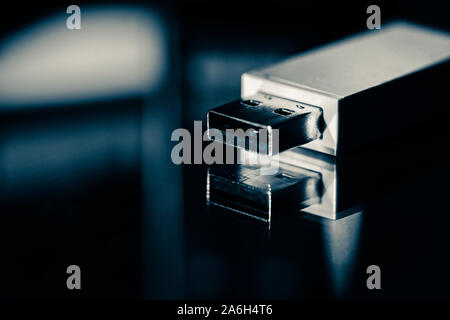 USB memory stick, bluetooth connection adapter on a mirrored background with studio lighting, close up Stock Photo