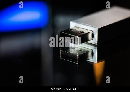 USB memory stick, bluetooth connection adapter on a mirrored background with studio lighting, close up Stock Photo