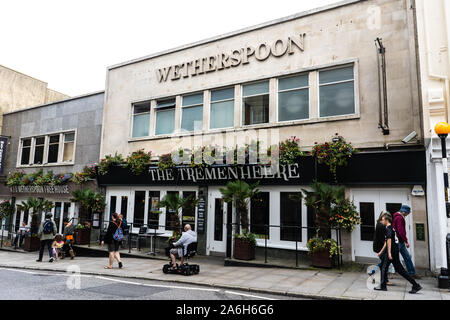 People walking by and entering the Tremenheere JD Wetherspoons pub in the highstreet of Penzance Stock Photo