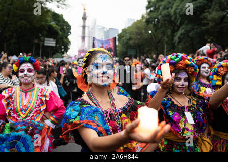 Mexico City, Mexico, 26/10/19, Women are seen dancing with candles as part of the Catrina procession in Mexico City. Credit: Lexie Harrison-Cripps/Alamy Live NewsMexico City, Mexico, 26/10/19,   The Catrina Procession is celebrated for the figure of Calavera Garbancera, originally created by Jose Guadalupe Posada.    Credit: Lexie Harrison-Cripps/Alamy Live News Stock Photo