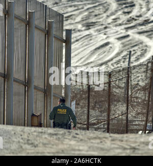 San Diego, California, USA. 26th Oct, 2019. A United States Border Patrol Agent walks along one of two border fences between the United States and Mexico. This section of the fence is at Border Field State Park, the southwestern corner of the continental United States. The southernmost fence extends several yards into the Pacific Ocean. Credit: David Barak/ZUMA Wire/Alamy Live News Stock Photo