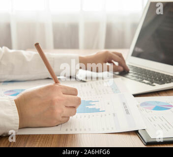 Businessmen are analyzed data from report and a laptop computer. Stock Photo