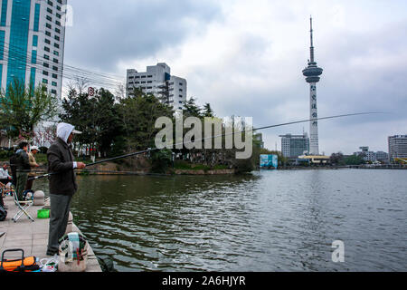 One Asian Chinese man fishing in pond in city. Stock Photo