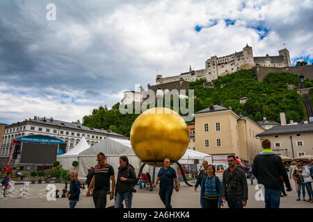 Kapitelplatz  square with Stephan Balkenhol - Sphaera, a sculpture of a man on a golden sphere on Kapitelplatz in Salzburg Old City, Austria. Stock Photo