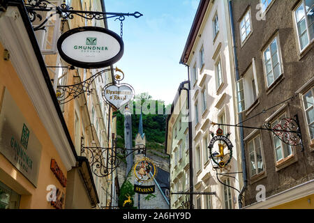 The Getreidegasse, famous shopping street in the Salzburg City, Mozart’s Birthplace ,destination for visitors from around the world. St.Blaise church. Stock Photo