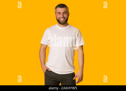 Positive bearded man posing over yellow background Stock Photo