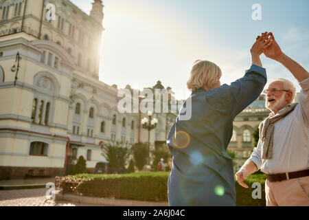 Feeling playful. Portrait of beautiful senior couple dancing together outdoors on a sunny day