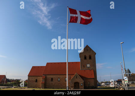 Big Denmark flag on the wind in front of church is seen in Hvide Sande, Denmark on 28 July 2019  © Michal Fludra / Alamy Live News Stock Photo