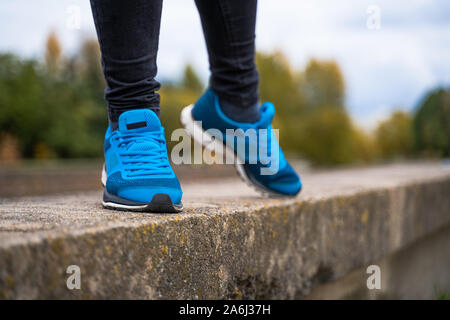 Blue sneakers on a woman legs. Outside workout in running shoes concept Stock Photo