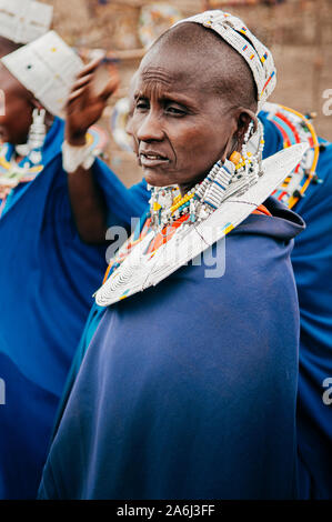 JUN 24, 2011 Serengeti, Tanzania - Portrait of African Masai or Maasai tribe woman in blue cloth wearing headpiece and stone beads ornaments. Ethnic g Stock Photo