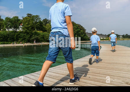 People walking by the The Infinite Bridge (Den Uendelige Bro) - circle shaped wooden pier built on a sea coast of a Aarhus Bay on a Varna Beach/Ballehage Beach, created by architect Niels Povlsgaard and Johan Gjødes  are seen in Aarhus, Denmark on 30 July 2019  © Michal Fludra / Alamy Live News
