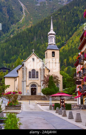 Chamonix Mont Blanc, France, street view with catholic church of St Michel in autumn, flowers and houses in town Stock Photo