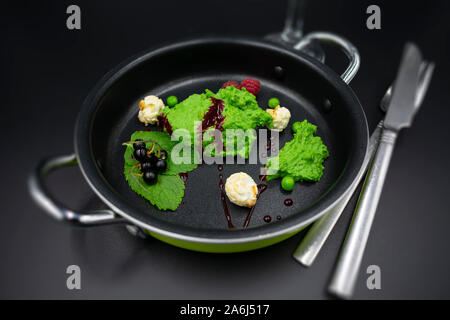 Pea mint sorbet with berries and popcorn with blurred background. Stock Photo