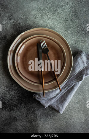 Cutlery set with empty plates on stone background with copy space Stock Photo