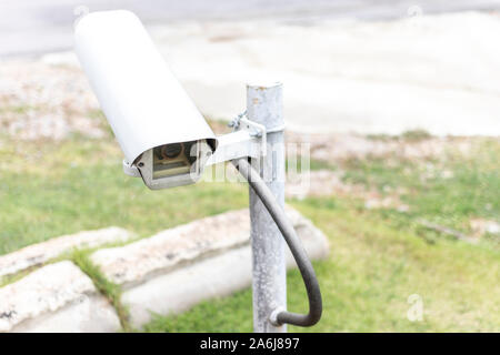 Old closed circuit camera separated in the garden. CCTV white security camera. Stock Photo