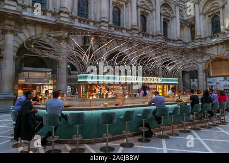 Leisure in the City after work: Well-stocked Fortnum & Mason wine bar with illuminated sign and name inside the Royal Exchange, City of London EC3 Stock Photo