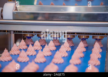 Cakes on automatic conveyor belt , process of baking in confectionery factory. Stock Photo