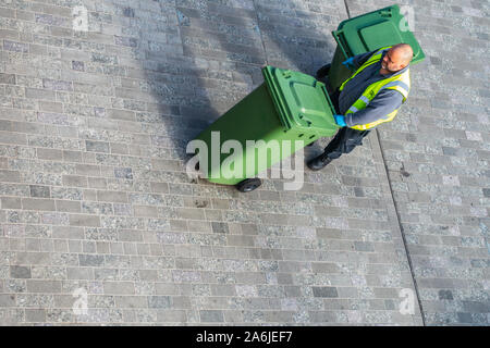 cleaner collecting rubbish bins from above Stock Photo