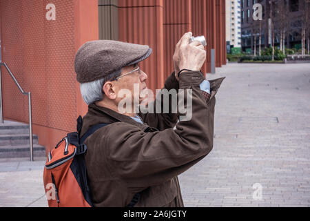 elderly asian man taking a photograph in London Stock Photo