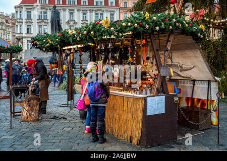 People stand near stall with craft souvenirs during famous traditional Christmas market in Prague, Czech Republic. Stock Photo